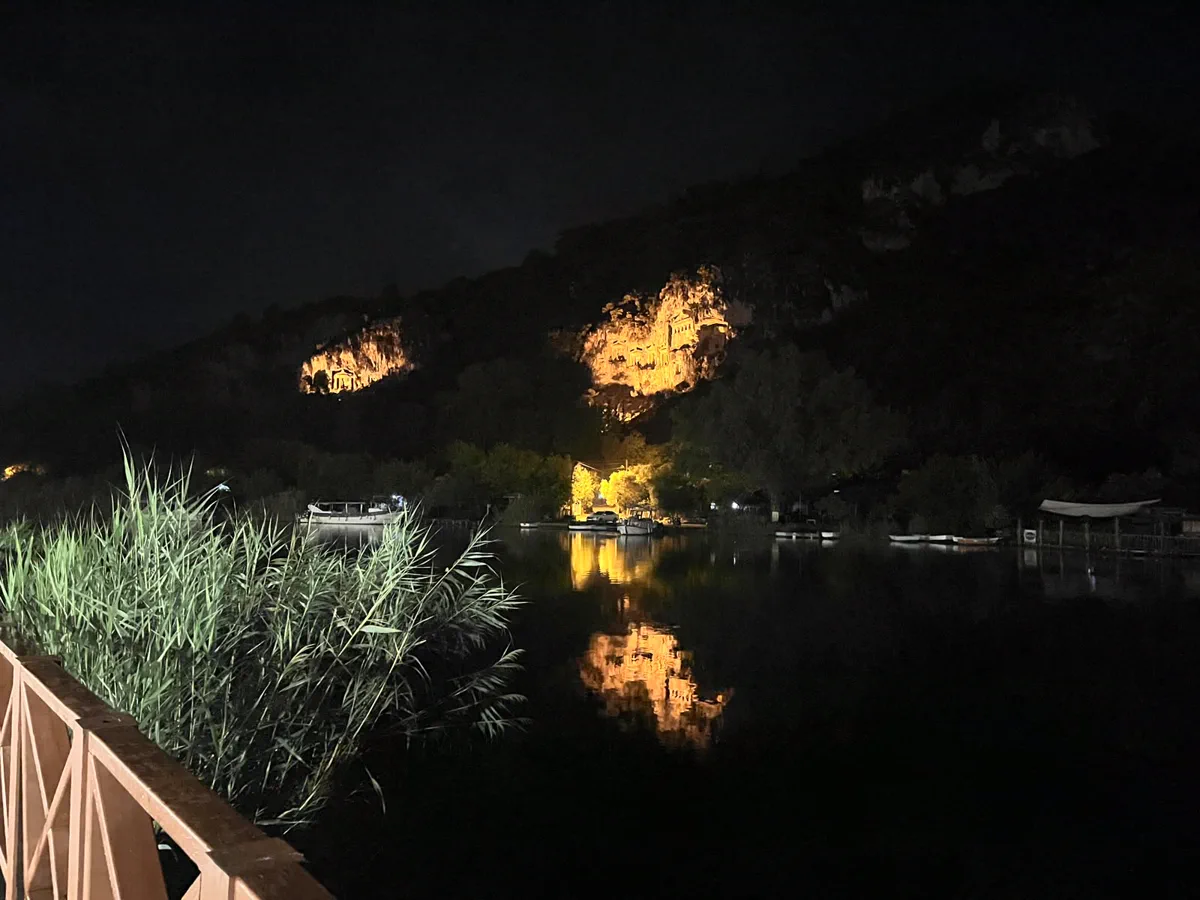 Gece ışıklandırılan Kaunos kaya mezarları ve mezarların Dalyan Çayı’na düşen turuncu yansıması