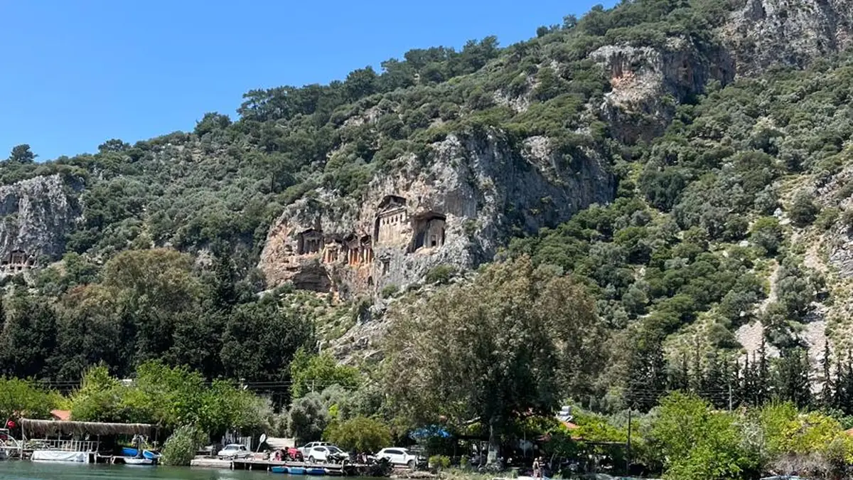 Dalyan Çayı’nın karşı kıyısındaki kayalığa oyulmuş Kaunos kral mezarları; tapınak cepheli mezarların sütunları ve alınlıkları seçiliyor